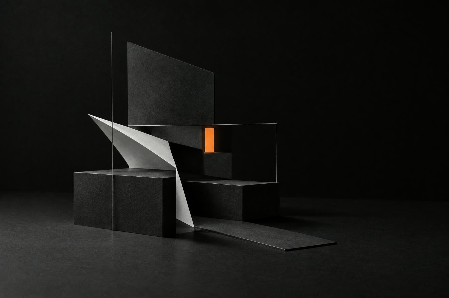 Abstract artwork: a black paper architectural model with a single glowing amber block